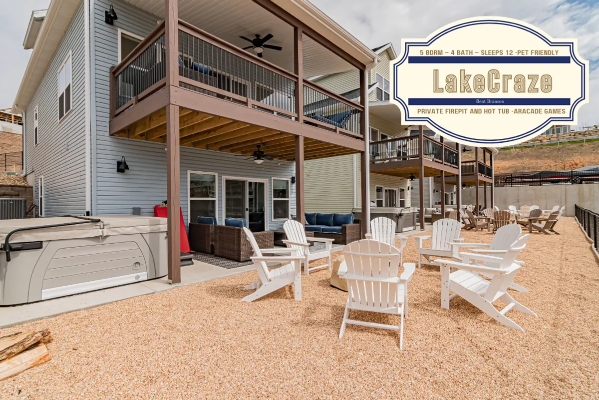 A welcoming backyard scene featuring a hot tub, fire pit, and outdoor seating, with a balcony visible above. The space invites guests to play outdoor games like cornhole or gather for evening relaxation, all within a secure, fenced setting.