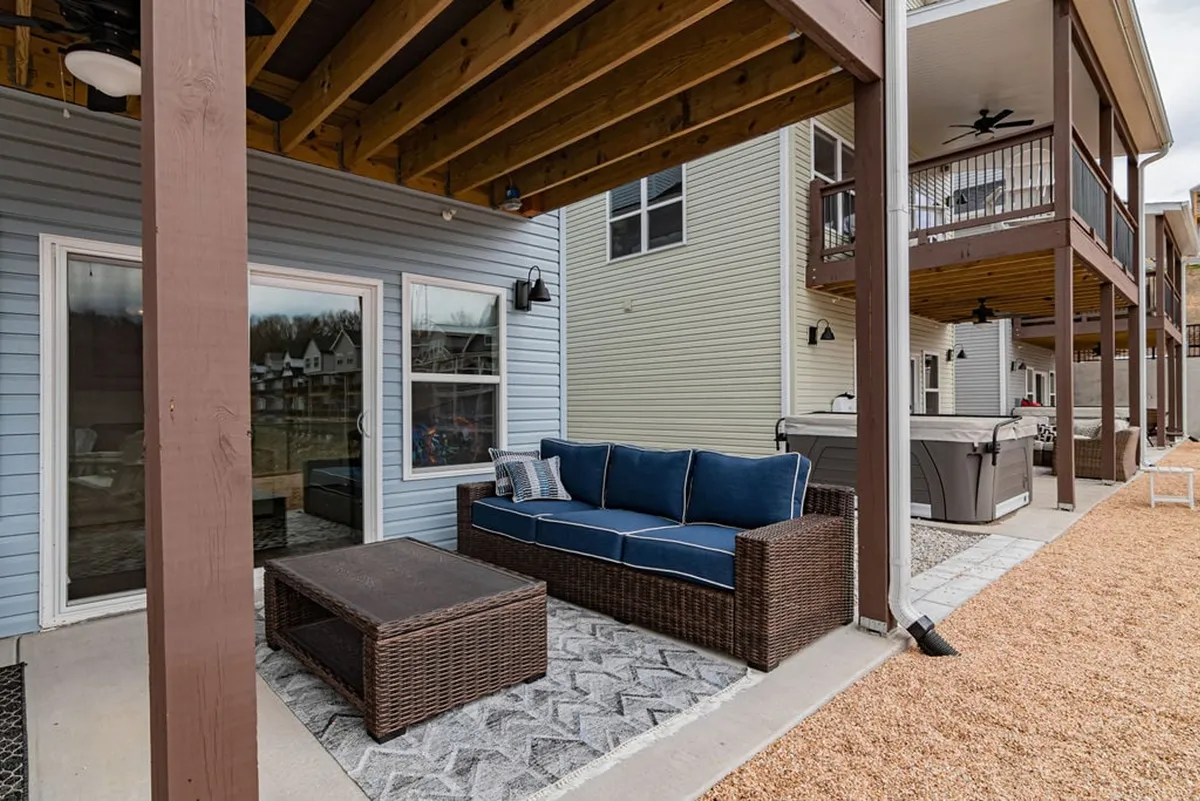 This image showcases a comfortable outdoor lounge space with a blue sofa and coffee table set against a scenic backdrop. The setting captures a relaxed, inviting atmosphere perfect for enjoying sunset views, outdoor movie nights, or barbecues with friends and family.