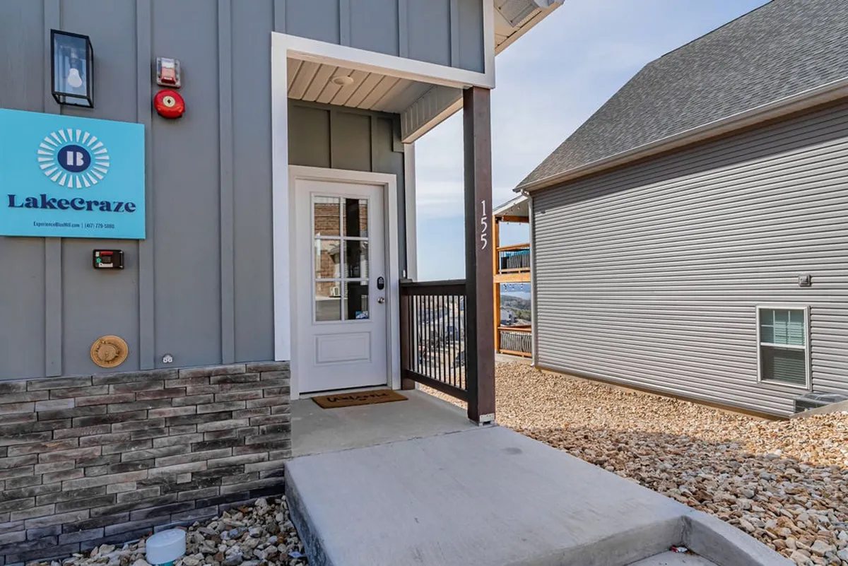 A clear view of the LakeCraze property entrance, with a welcoming stone pathway and the Lakecraze sign, inviting guests to enter. The scene conveys arrival and anticipation for group adventures and memorable stays.
